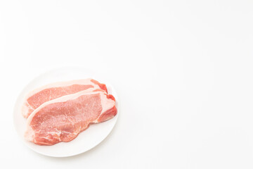 皿に乗った豚ロース肉　白バック