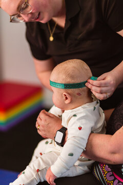 Physio performing Cranial Measurement assessment on baby