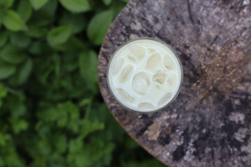 green healthy matcha tea in a transparent glass on a wooden stump