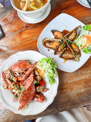 Dishes with crab and mussels in sauce on white plates. seafood in restaurant