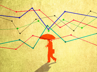 Business person with umbrella walking among volatile financial graphs