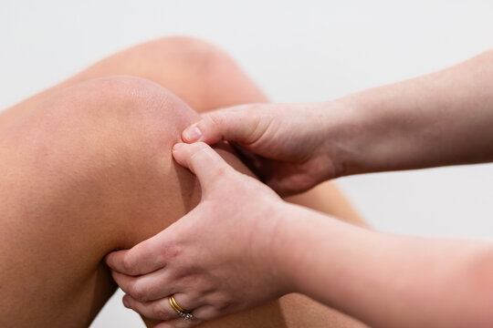 Physio assessing knee injury