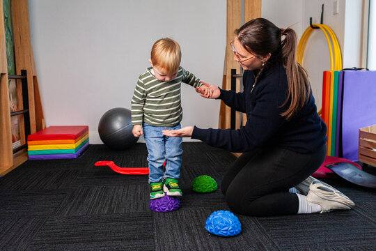 Child with female physiotherapist working on balance together in clinic