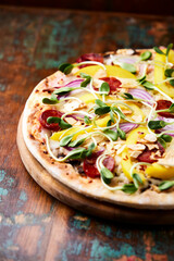 Pizza with chorizo ​​sausage, mozzarella cheese and yellow pepper. Rustic wooden background. Soft focus.	