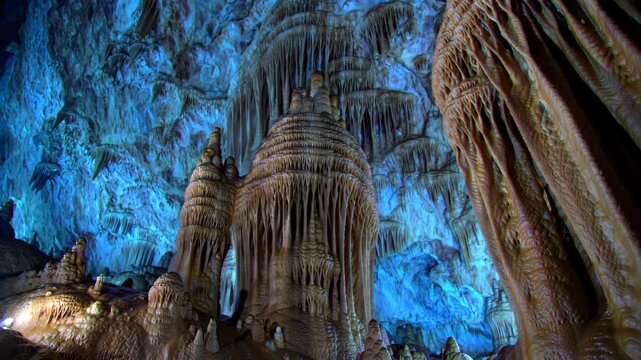 Spectacular stalactites and stalagmites illuminate the blue Grotte di Castellana cave in Italy, natural wonder, travel, geology, cave formations.