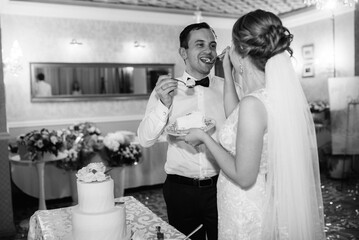 newlyweds happily cut and taste the wedding cake