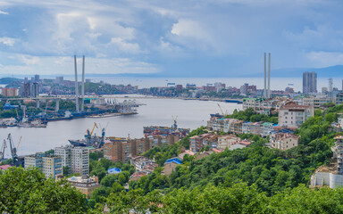 Vladivostok city center and Golden Horn Bay panoramic view at Russia, with Golden Bridge and ships near Churkin Peninsula on a clear summer day.
