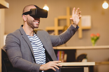 VR headset is sitting on wooden desk with pink tulips and glowing pendant lights near shelf