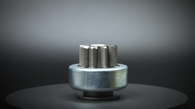 Car starter drive, bendix. Starter part, rotation on black background close-up. Spare parts.