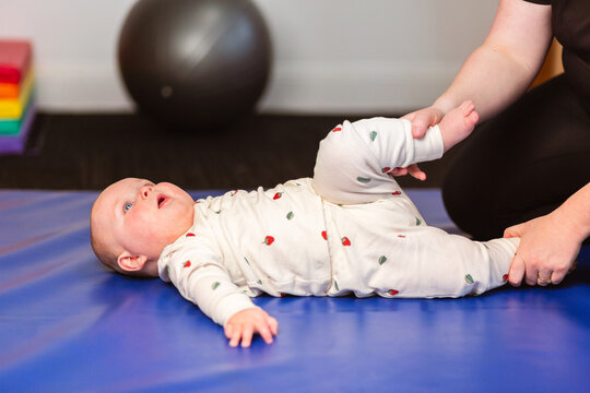 physiotherapist woman working with baby on therapy mat
