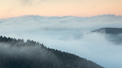 Burgruine Meistersel im Pfälzerwald bei Sonnenaufgang mit Hügeln im Nebelmeer wie kleine Inseln
