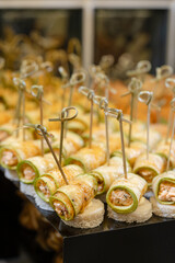Zucchini rolls with filling on white base elegant appetizers for event.