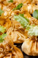 Golden fried dumplings in pouch shape with fresh lettuce