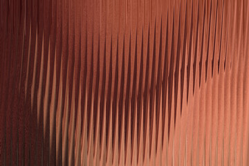A closeup view of a textured copper surface with vertical ribbed patterns creating a sense of depth and shadow