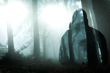 a double exposure of a spooky ghost like hooded figure, with glowing UFOs in a foggy forest