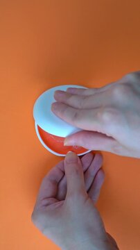  Opening White and Orange Dental Aligner Case that are Orthodontic Mouthpiece storage in orange background. Slow motion. vertical video.