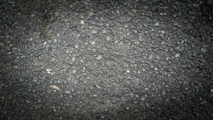 Close up of black asphalt road surface with small gravel and rough texture