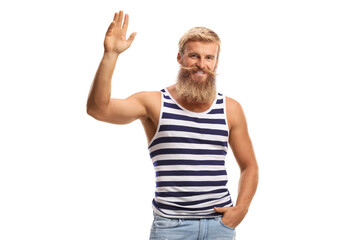 Fototapeta premium Guy with beard and mustache wearing a striped vest and jeans and waving at the camera