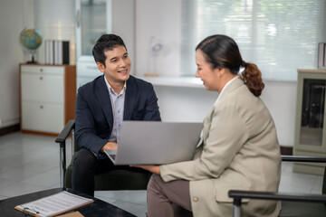Business people discussing work using laptop in office