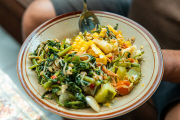 Close-up of a traditional Indonesian healthy dish with fresh vegetables, corn, bean sprouts, and greens. Nutritious homemade food concept, perfect for diet, organic lifestyle, and local cuisine.
