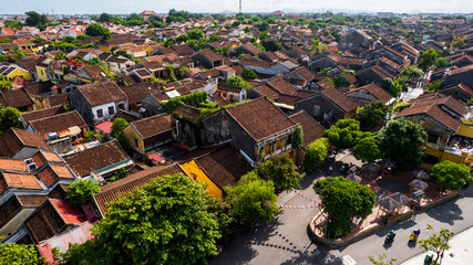 a peaceful view of Hoi An's historic riverside, with its charming yellow-walled buildings and...