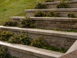 A detailed view of a terraced stone retaining wall, showcasing sophisticated landscape architecture...
