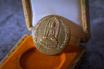 Brass buddha medal with detailed golden design suitable for religious and spiritual themes. Ideal for jewelry, decor, and meditation concepts.