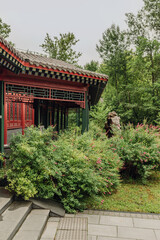 Fototapeta premium Close-up of a beautifully designed traditional structure surrounded by greenery and tranquility. Chinese traditional architecture and garden. 
