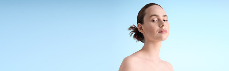 Fashionable young woman exuding confidence against a serene blue backdrop in a modern setting