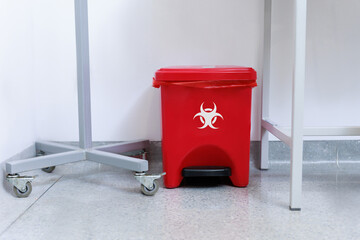 Medical waste disposal room with red biohazard containers and bins