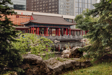 Japanese garden. A tranquil pond reflects the surrounding greenery and traditional structures, enhancing the beauty of the natural landscape