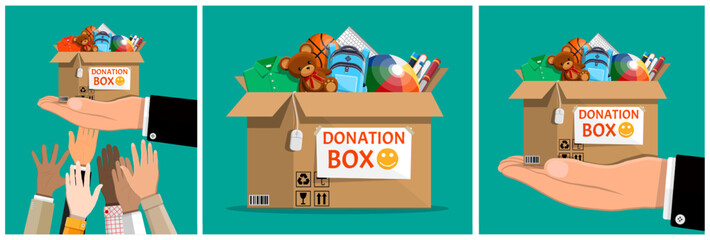 Man hands holding donation box with clothes, toys, books, and school supplies for charity. Volunteering and social assistance concept.