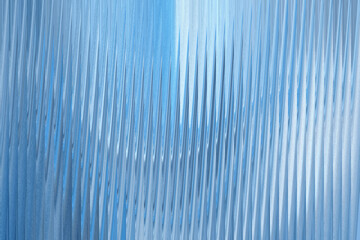 A closeup abstract view of a textured blue surface with vertical ribbed patterns, creating a sense...