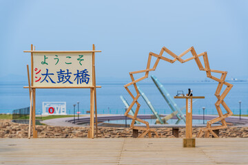 Izumisano, Osaka, Japan. Taiko Bridge welcome sign and wooden arch art installation at Rinku Park, a popular seaside park located in Izumisano City.
