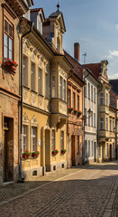 Fototapeta premium Historic street of renovated old homes and buildings with a cobblestone road, representing urban gentrification background.
