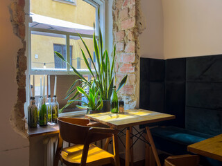Window with sunlight in home interior. Cosy room with elegant furniture, wooden table, comfortable