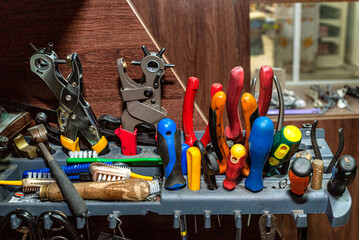 A close-up of shoe repair equipment, highlighting tools and materials used for crafting and fixing footwear in a workshop setting