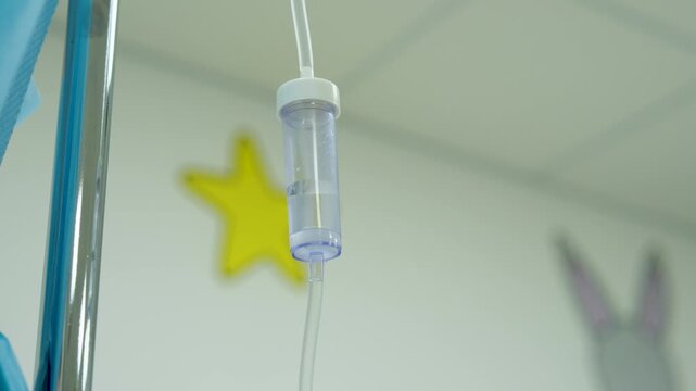 Medical drip chamber hanging in pediatric hospital room, steadily delivering essential fluids and targeted medications while supporting young patient's recovery process
