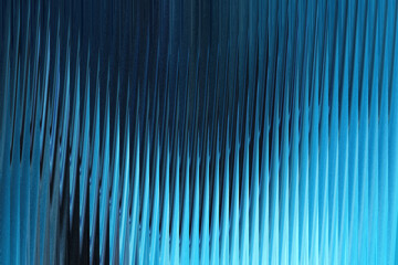 A closeup abstract view of textured blue glass with vertical ridges, creating a mesmerizing pattern...