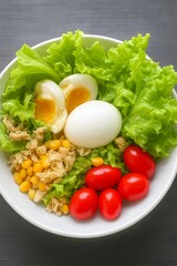 Fresh Healthy Salad with Eggs Tomatoes Corn and Lettuce in White Bowl.