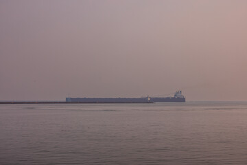 A Ship Leaving A Harbor On Lake Superior On A Wildfire Smokey Hazy Evening