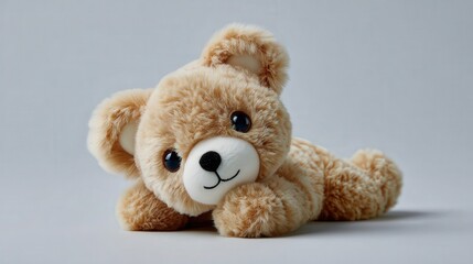 Obraz premium An adorable plush teddy bear rests on a light background, evoking feelings of comfort and nostalgia, Perfect for children's products, toys, or gift-related designs,