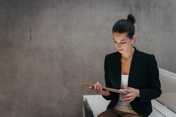 Portrait of young businesswoman working on tablet in office.