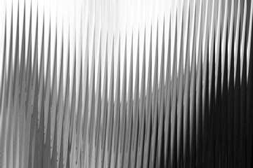 A textured abstract background with vertical, sharp, pointed lines that create a sense of depth and movement, rendered in grayscale