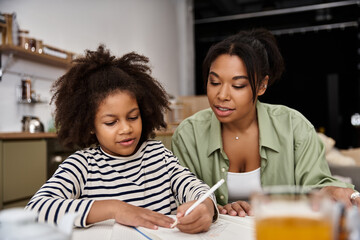 Obraz premium Mother and daughter sharing a creative moment at home together in a cozy environment