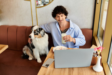 Handsome young man enjoying a refreshing drink with his dog at a cozy cafe