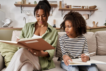 Mother and daughter share quality time at home while working on creative projects