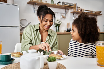 Joyful breakfast moments between a mother and daughter at home in a cozy kitchen