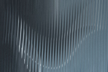 A closeup abstract view of a corrugated metal surface with a textured, ribbed pattern creating a sense of depth and shadow
