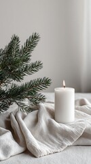 A candle is lit on a white cloth next to a pine tree